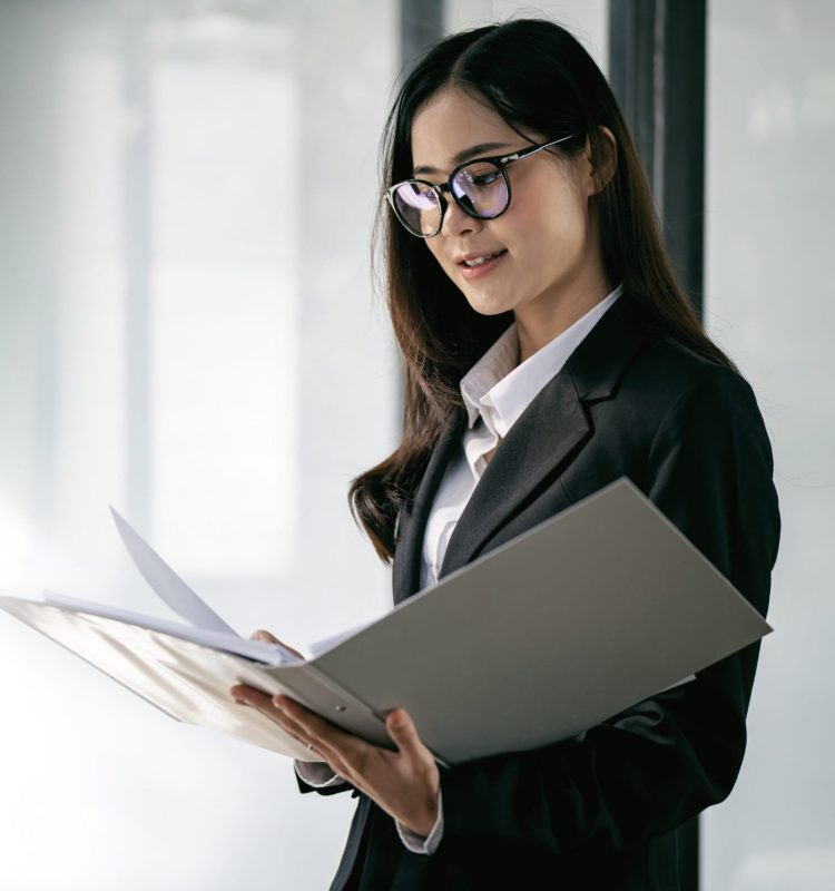 Professional businesswoman checking on paperwork at modern office.